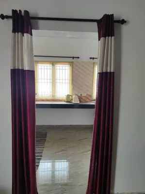 a view of a room with a curtain in a room at MMVK Homestay AC, Spacious & Comfortable Entire Home Just For You in Pollāchi