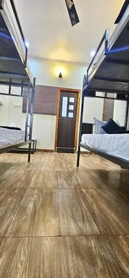 a room with two bunk beds and a wooden floor at Beedu - Backpackers Hostel in Mysore
