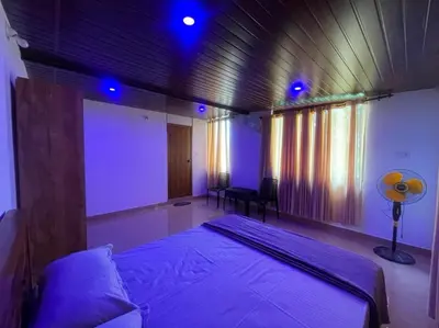 a bedroom with a bed in a room with blue lights at Tjmaryland villa in Pinangode