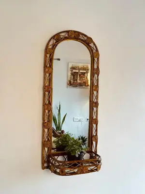 a mirror hanging on a wall with a plant at Casa Serenity in Ooty