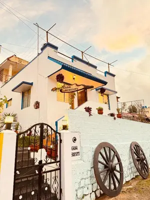 a white house with a cannon in front of it at Casa Serenity in Ooty