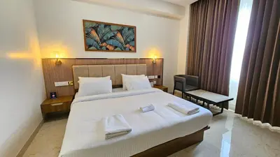 a bedroom with a large white bed with towels on it at Prosland Hotel in Tirūr