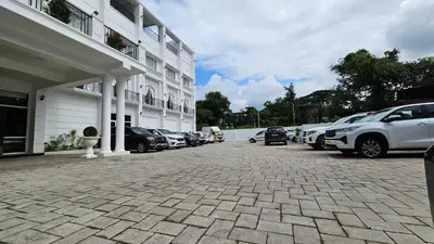 a parking lot with cars parked next to a building at Prosland Hotel in Tirūr