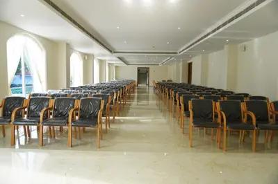 a room with a row of chairs in a hall at Prosland Hotel in Tirūr