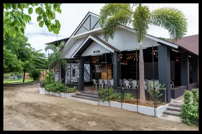 a house with chairs and plants in front of it at Serene Meadows Resort in Kāramadai