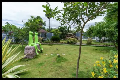 a park with a green sculpture in the grass at Serene Meadows Resort in Kāramadai