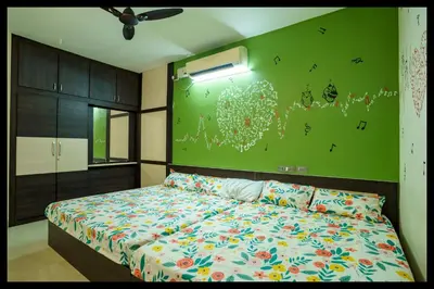a bedroom with a bed and a green wall at Serene Meadows Resort in Kāramadai