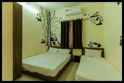 a bedroom with two beds and a panda picture on the wall at Serene Meadows Resort in Kāramadai