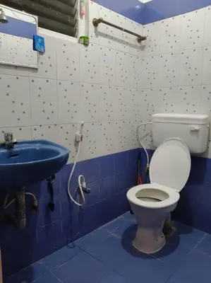 a bathroom with a toilet and a sink at Padmam Service Apartments - 2BHK in Singānallūr