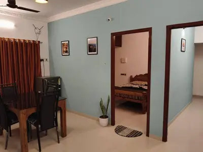 a room with a mirror and a bedroom with a bed at Padmam Service Apartments - 2BHK in Singānallūr