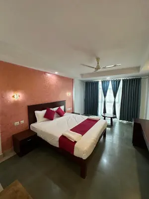 a bedroom with a large bed with red pillows at CRYSTAL Inn in Kalpetta