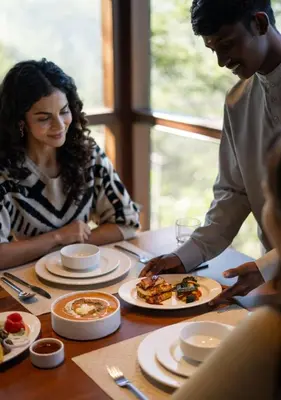 a group of people sitting at a table eating food at LohonoStays Amani Villa 10A in Coonoor