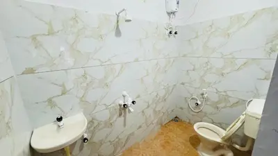 a bathroom with a toilet and a sink at Mysuru-hotel in Mysore