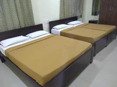 three beds sitting in a room withermott at Mysuru-hotel in Mysore
