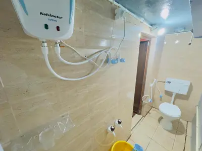 a bathroom with a white toilet and a shower at Mysuru-hotel in Mysore