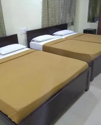 a group of three beds in a room at Mysuru-hotel in Mysore