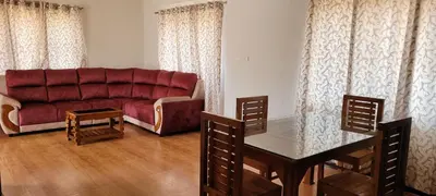 a living room with a red couch and a table at AJ Groups B&B Residency in Ooty