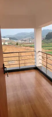 a room with a balcony with a view of a field at AJ Groups B&B Residency in Ooty
