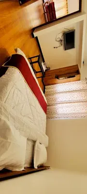 a bedroom with a bed with a red and white pillow at AJ Groups B&B Residency in Ooty