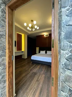 a bedroom with a bed and a stone wall at RR Forest View in Ooty