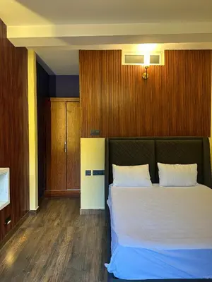 a bedroom with a large bed with a wooden wall at RR Forest View in Ooty