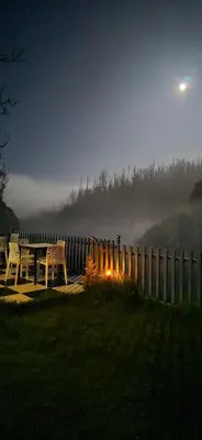 two chairs and a table next to a fence at RR Forest View in Ooty