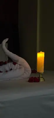 a candle sitting next to two towels and a candle holder at RR Forest View in Ooty