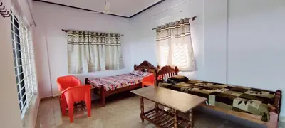a room with a bed and a table and chairs at Nature stay Mysore in Mandya