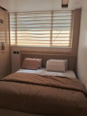 a bed with two pillows sitting under a window at Blue mount stay in Gūdalūr