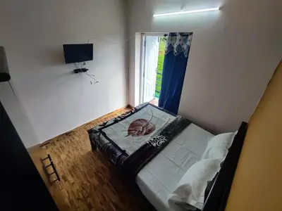 a small bedroom with a bed and a window at Ooty Horizon Heights in Ooty