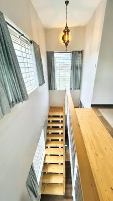 a room with stairs and a window and a chandelier at Away From Home - 4 - Rooms In Ooty, Home Stay Ooty in Ooty