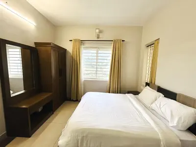a bedroom with a large bed and a window at Away From Home - 4 - Rooms In Ooty, Home Stay Ooty in Ooty