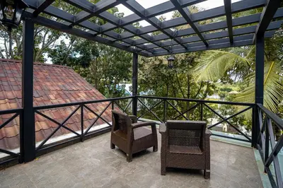 a patio with two chairs and a pergola at Regenta Resort Mysore Tropical Village in Chāmundi
