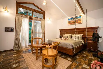 a bedroom with a swing bed and a table at Regenta Resort Mysore Tropical Village in Chāmundi