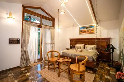 a bedroom with a bed and a table and chairs at Regenta Resort Mysore Tropical Village in Chāmundi