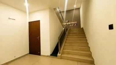 a staircase in a building with a wooden door at BINI Heritage in Trichūr