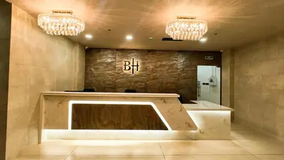 a lobby with a reception desk and two chandeliers at BINI Heritage in Trichūr