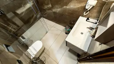 a bathroom with a white sink and a toilet at BINI Heritage in Trichūr
