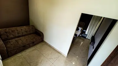 a living room with a couch and a mirror at BINI Heritage in Trichūr