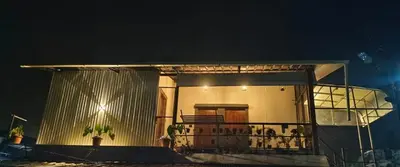 a small house with a balcony at night at Birdwing Cottage, Munnar in Munnar