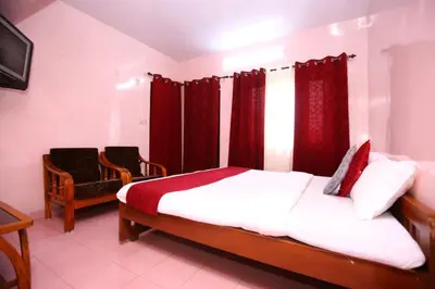 a bedroom with a bed with red curtains at Janani Cottage in Ooty