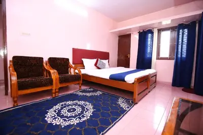 a small bedroom with a bed and a chair at Janani Cottage in Ooty