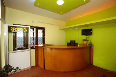 a reception desk in a room with green walls at Janani Cottage in Ooty