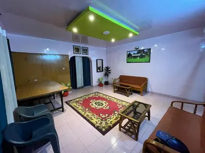 a living room with a table and a rug at Janani Cottage in Ooty