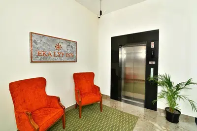 two orange chairs in a room with a elevator at Eka Lyf Inn in Coimbatore