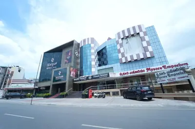 a building with a car parked in front of it at Mazus Urban Express in Mysore