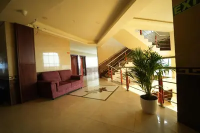 a living room with a couch and a potted plant at Mazus Urban Express in Mysore