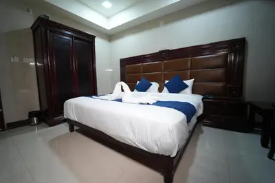 a bedroom with a large bed with two swans on it at Mazus Urban Express in Mysore