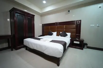 a bedroom with a large bed with a wooden headboard at Mazus Urban Express in Mysore