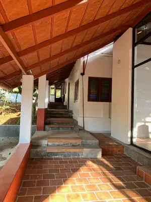 a staircase leading up to a building with a wooden ceiling at Cuppa Creek Homestay in Madikeri